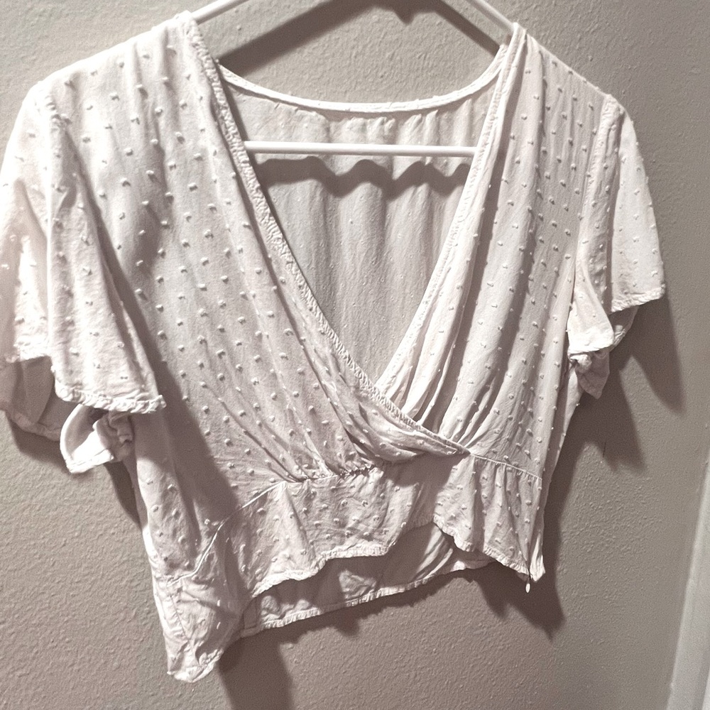 White crop top shirt with cross belly design and detailing on fabric